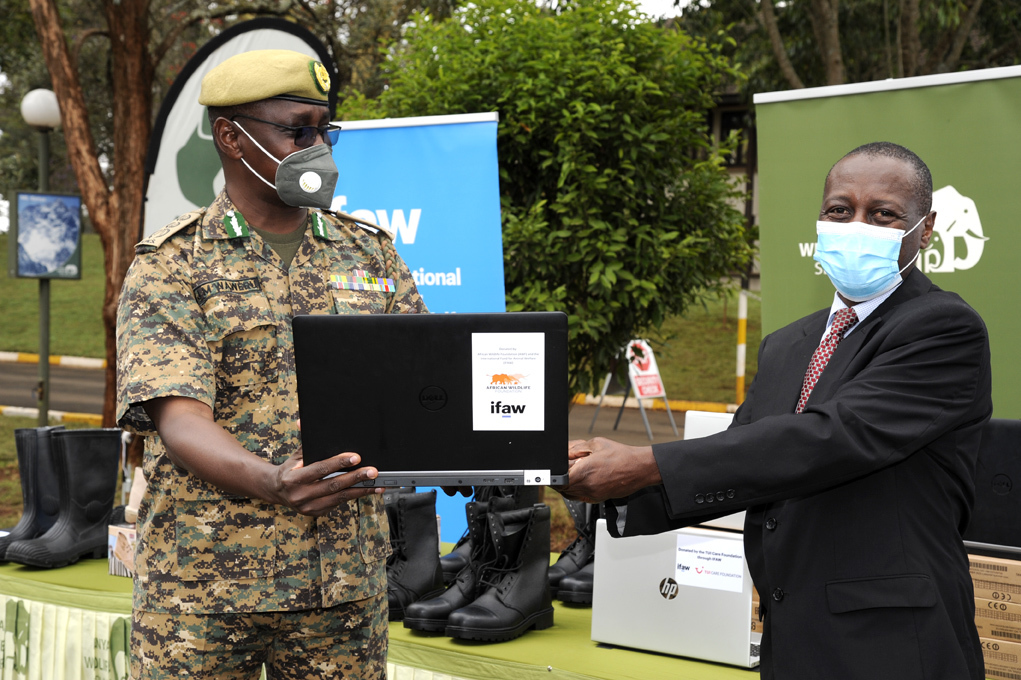 John Waweru receives a laptop from James Isiche. 