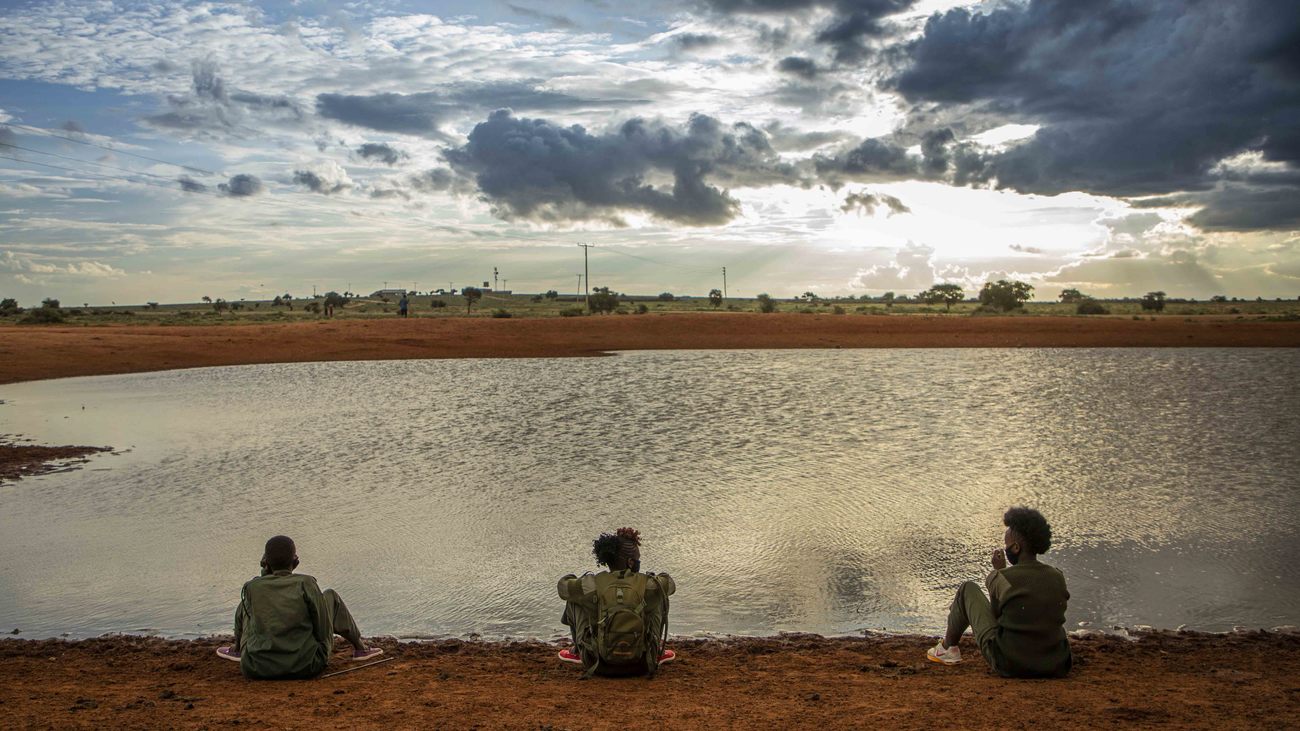  trois femmes sont assises à un point d'eau au Kenya