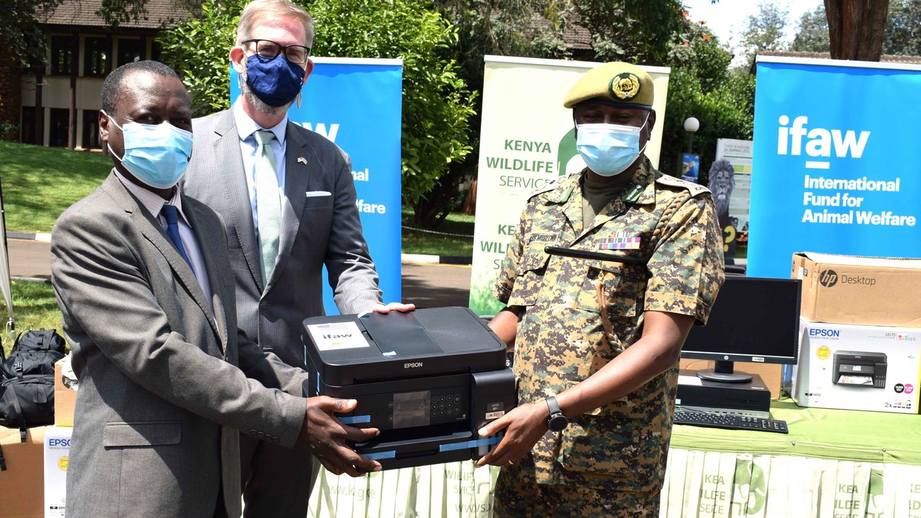 two directors and a ranger hold a printer for display