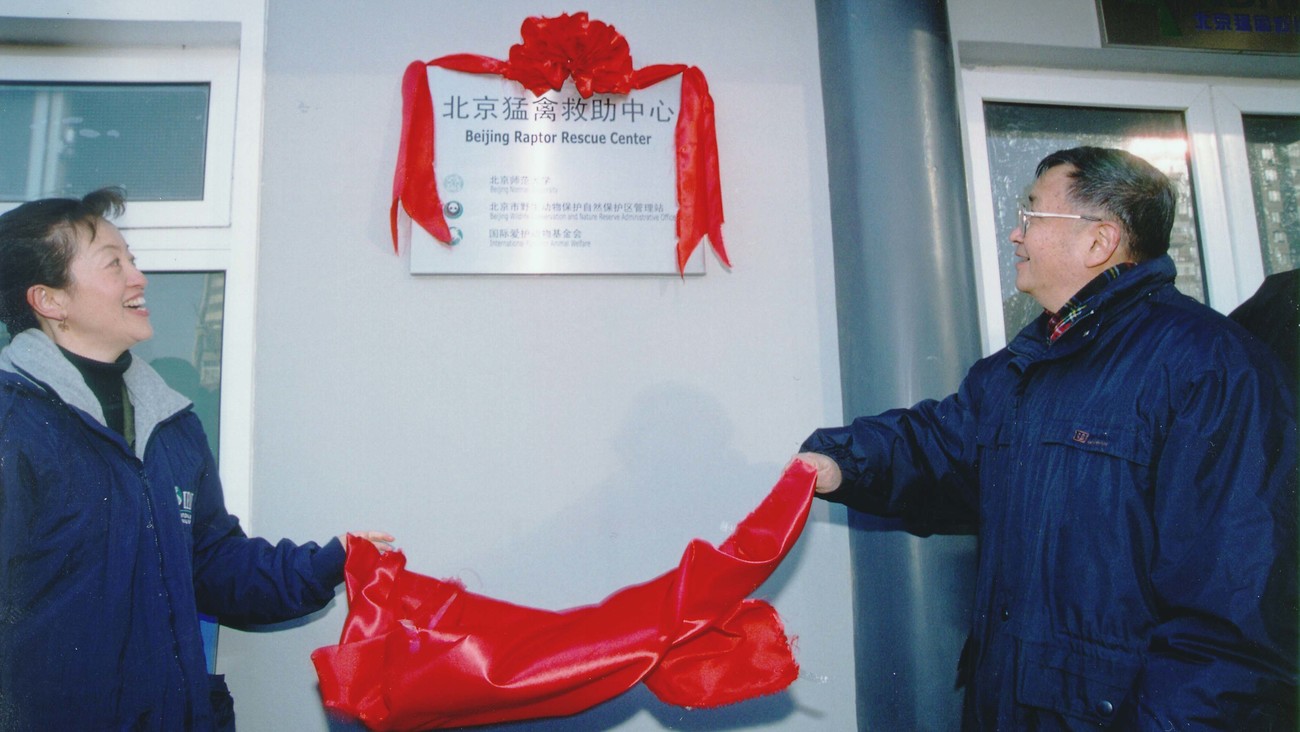 Grace Gabriel and Liang Cong Jie unveil the Beijing Raptor Rescue Sign sign with red ribbon