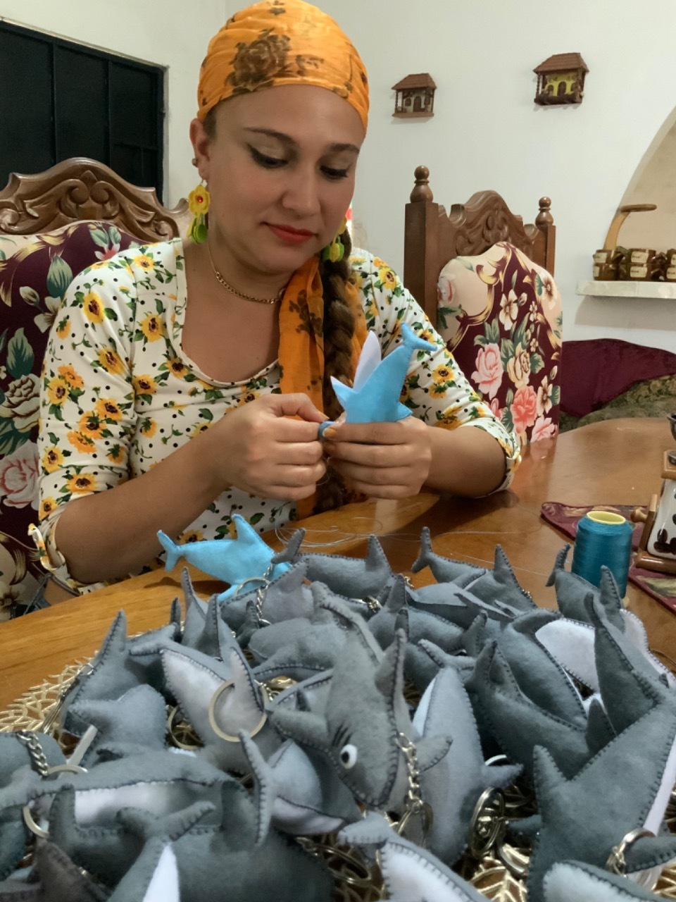 woman handcrafts shark key chains of crochet in Panama