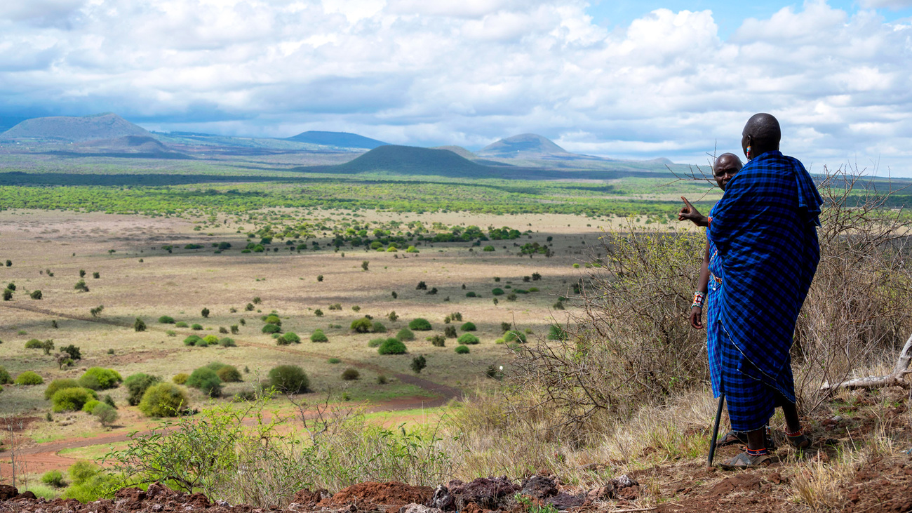 Leden van de Olgulului Ololarashi Group Ranch kijken uit over het landschap van Amboseli.