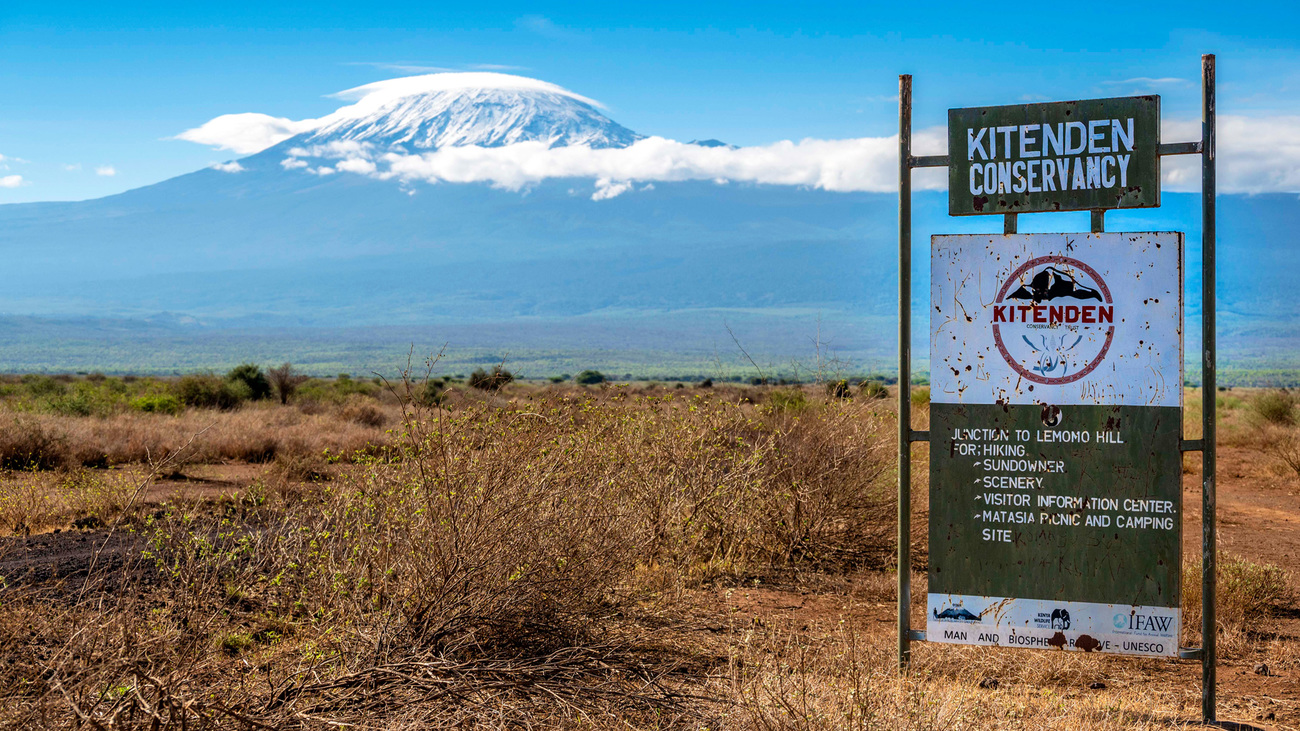 Het bord van Kitenden Conservancy tegen het landschap van de Kilimanjaro.