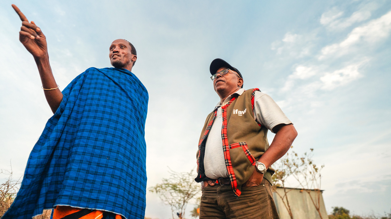 Evan Mkala, un employé d’IFAW (à droite), dialogue avec un chef communautaire au sein de la réserve naturelle Kitenden Conservancy, au Kenya. 