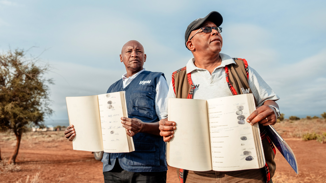 IFAW's Bernard Tulito (left) and Evan Mkala (right) holding the signatures of community members who signed the lease for the Kitenden Conservancy, Kenya.