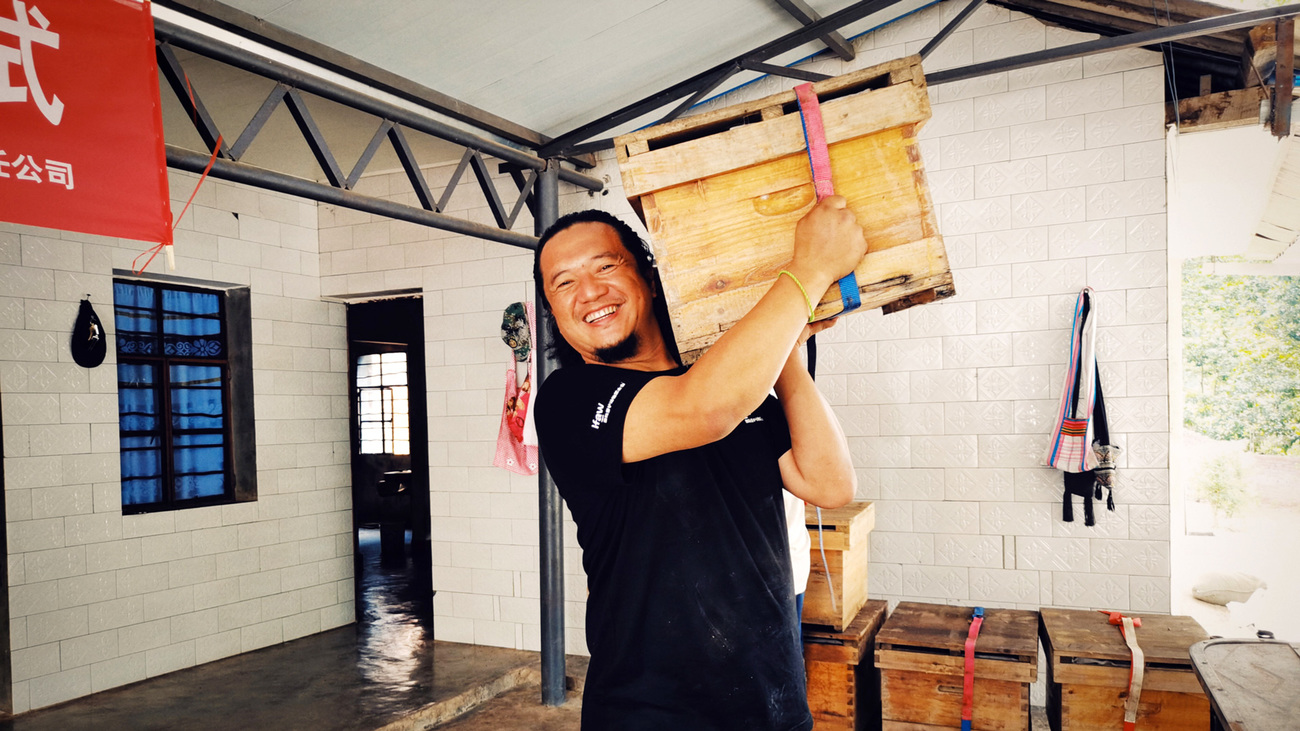 IFAW staff, Dafan Cao, carrying a beehive on his shoulder as he aids local Daotangjing villagers loading up hives for transport back to their village.