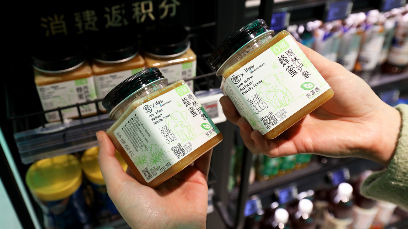 A consumer examines “Zero Carbon Elephant-Friendly Honey” produced by IFAW’s beekeeping project in Daotangqing village.