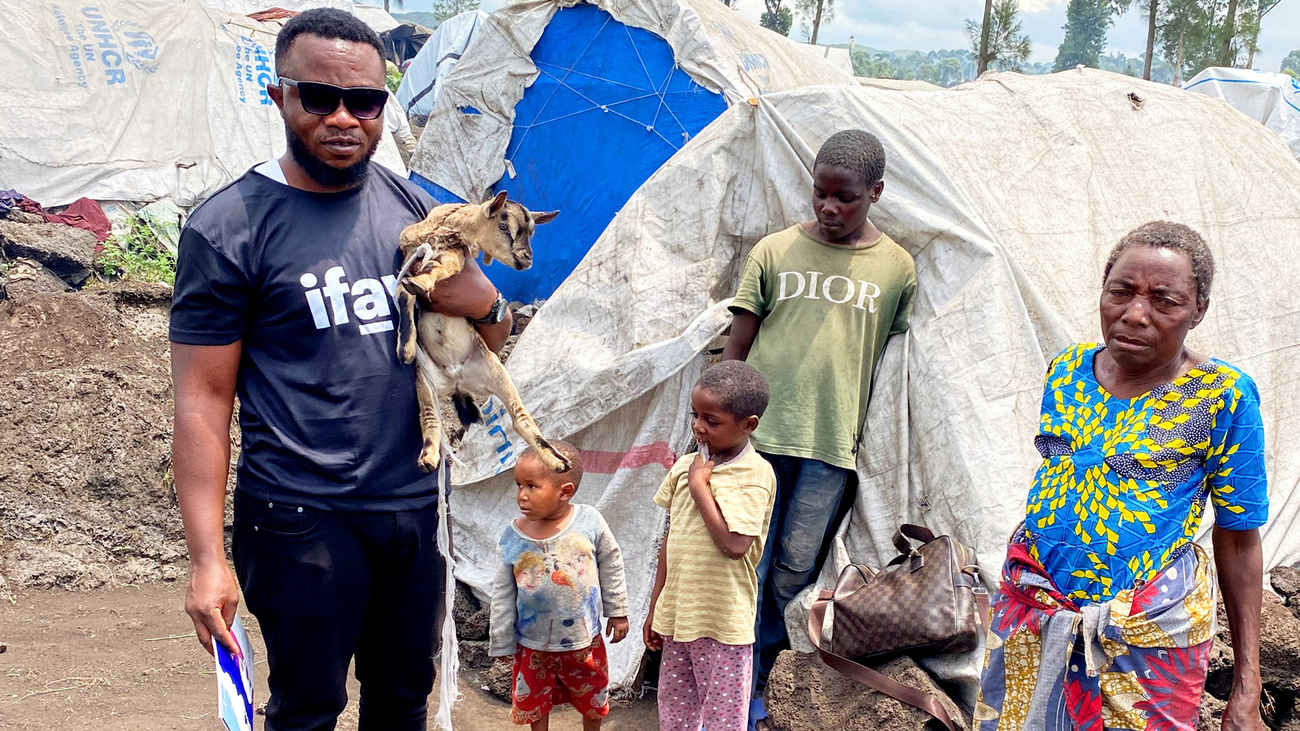 Masika Kavira Yvette (right) stands outside her temporary tent with her children and goat at Mungunga Camp as Paterne Bushunju (left), Founder and President of Sauvons nos Animaux, closely assesses the condition of Masika’s goat—Masika had to leave her dog at the gate of the camp for hygiene reasons, forcing her to abandon her faithful companion.