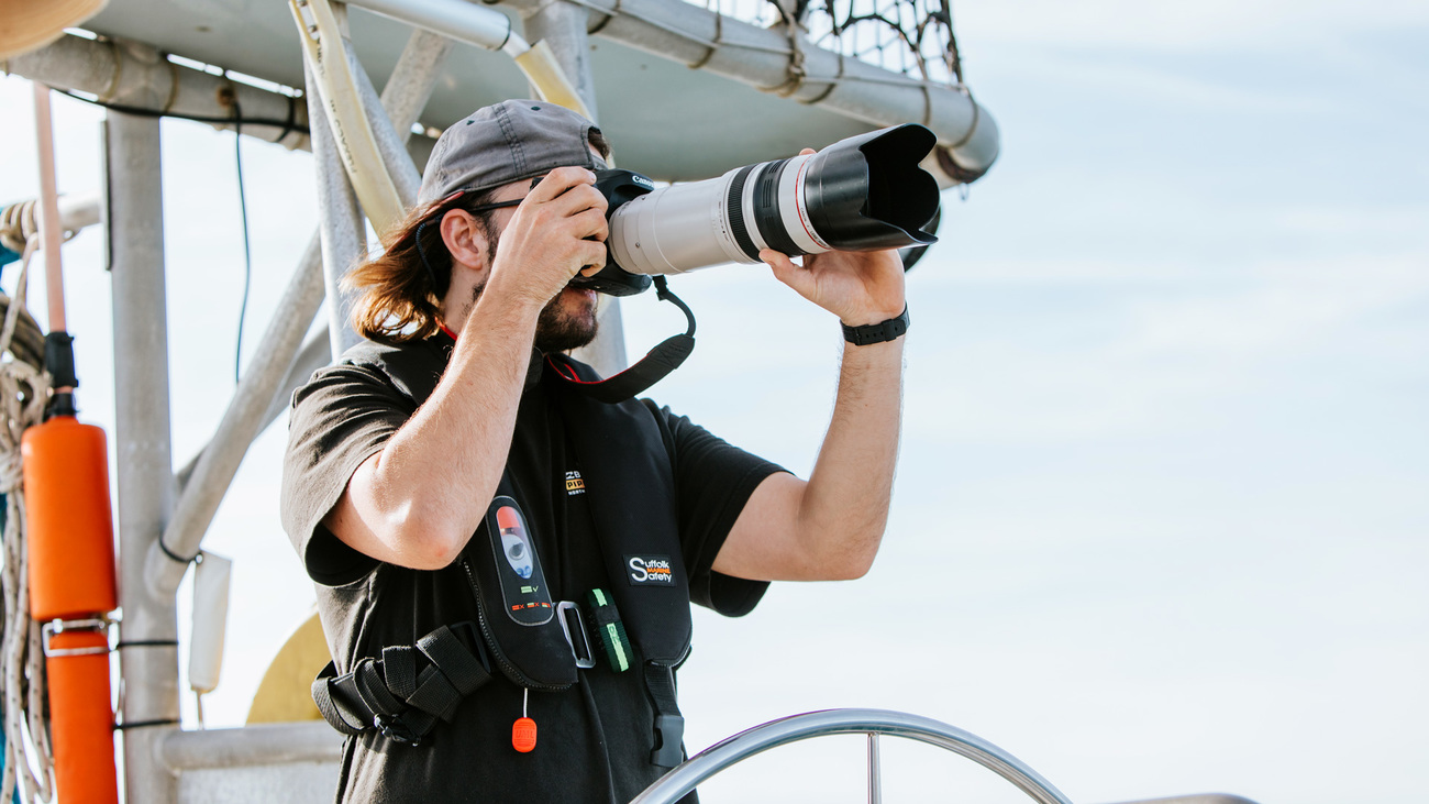 First mate Killian Glynn photographs marine animal sightings on research vessel Song of the Whale.