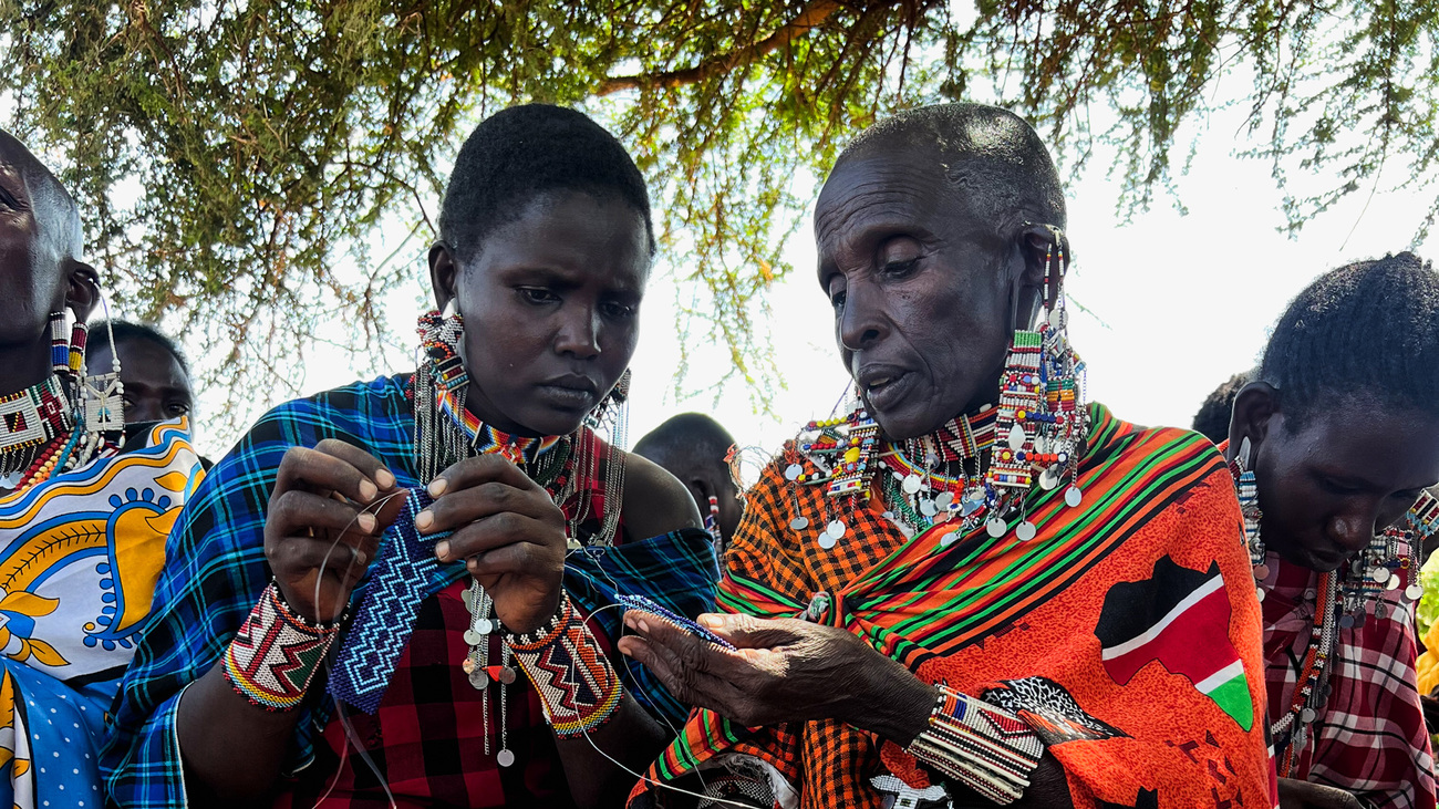 Inua Kijiji project participants inspect their beadwork.