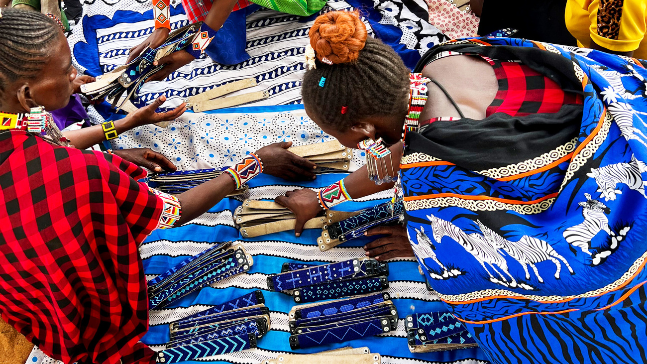 Women participating in the Inua Kijiji project with beaded bracelets they’ve made.