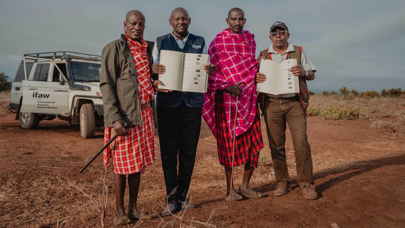 Bernard Tulito (tweede van links) en Evan Mkala (rechts) van IFAW tekenden met duizenden grondeigenaren een overeenkomst om Kitenden Conservancy in Kenia veilig te stellen voor wilde dieren.