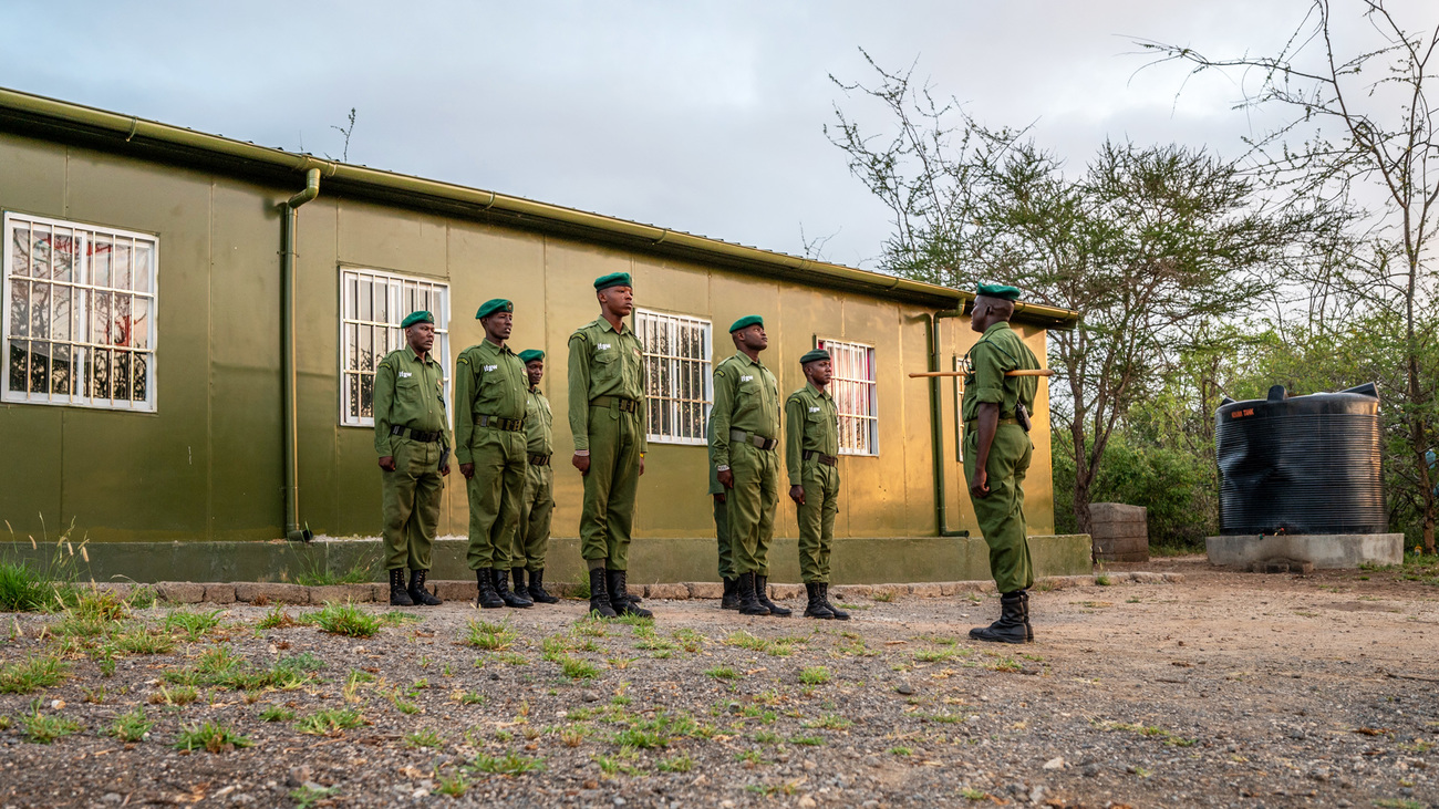 Rangers at the David Rio ranger base warm up before their routine morning foot patrol in Illaingarunyoni Conservancy.