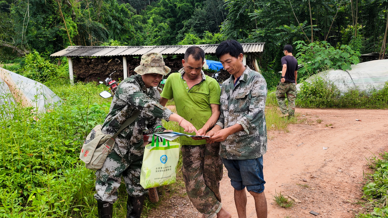 Ranger Li Jie discusses human-elephant coexistence practices with community members in a rural area near Mengla County, China.