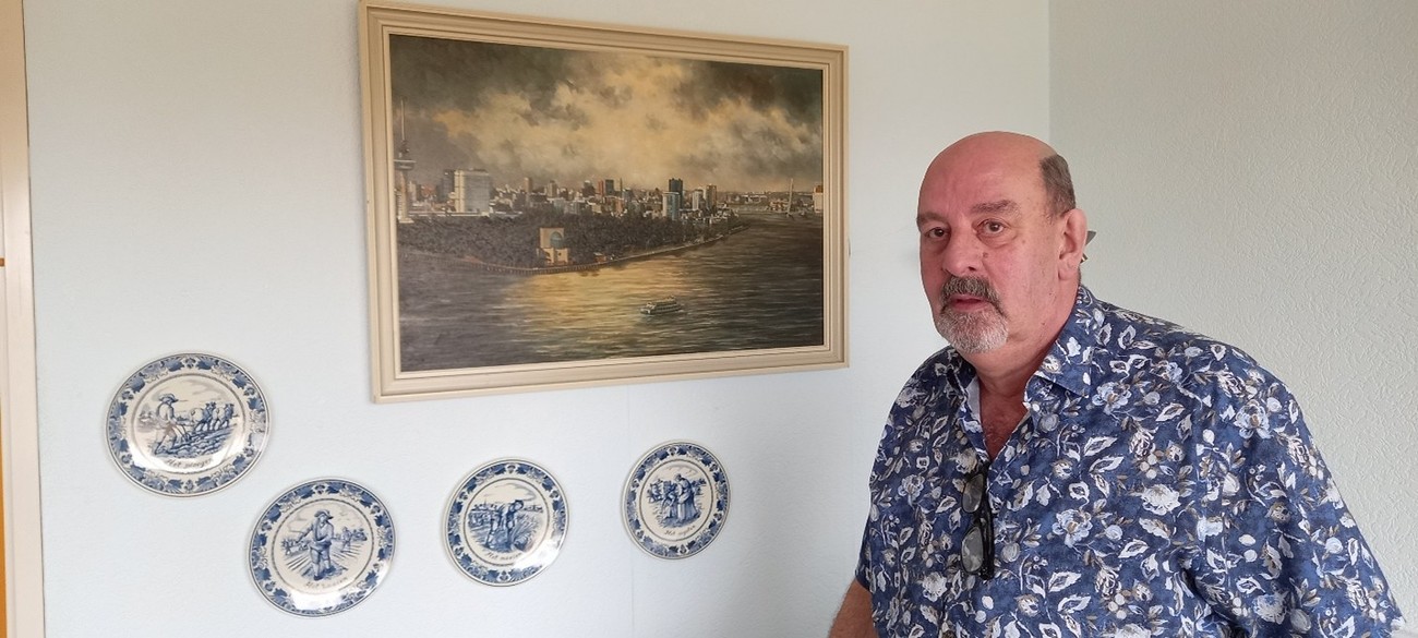 René Troost bij een schilderij en Delfts blauwe borden.