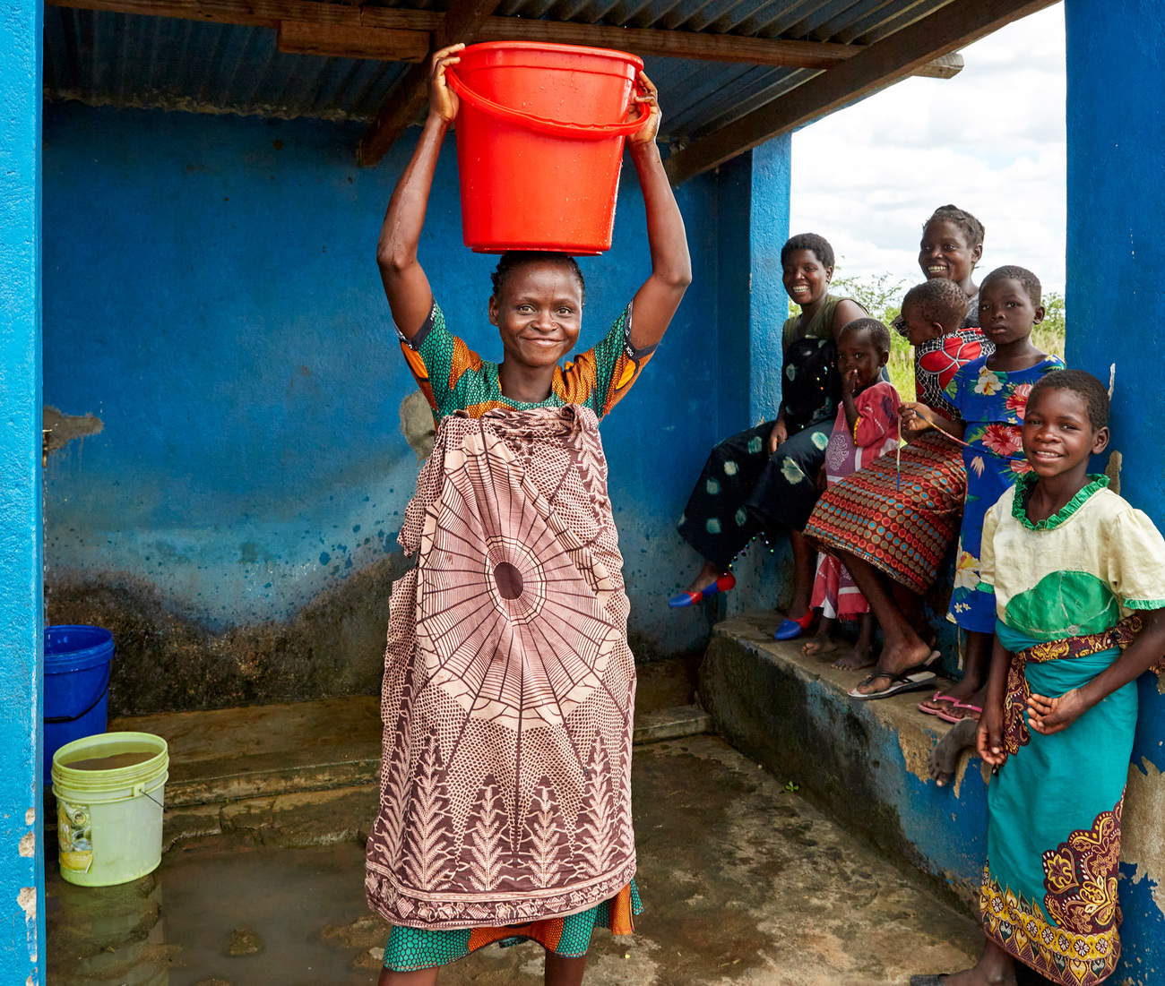 Gloria Mbetewa and other Chikolongo community members at a water tap installed as part of the Chikolongo, Malawi.