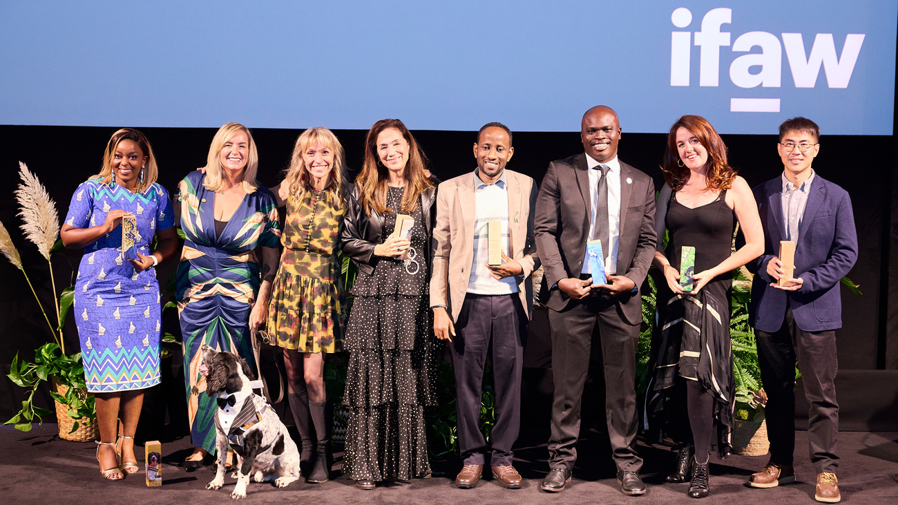 (From left to right) Ever Vimbai Chinoda, Louise Wilson, Henry the dog, Michaela Strachan, Cristina Mittermeier, Dr Abdullahi Ali, Jamal Galves, Rebecca Henschke and Baidu’s Wang Di onstage holding their awards at IFAW’s 2025 Animal Action Awards.