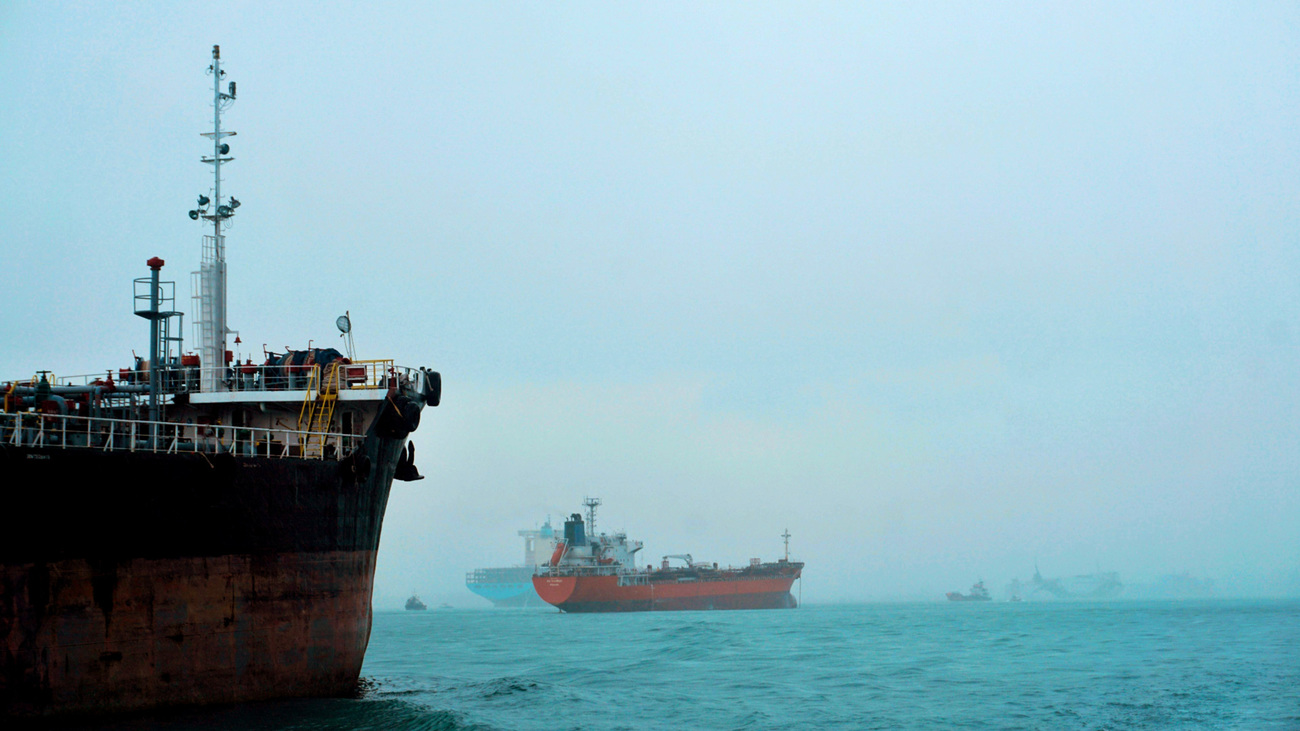 Cargo ships navigate a foggy ocean, highlighting global logistics and transportation. 