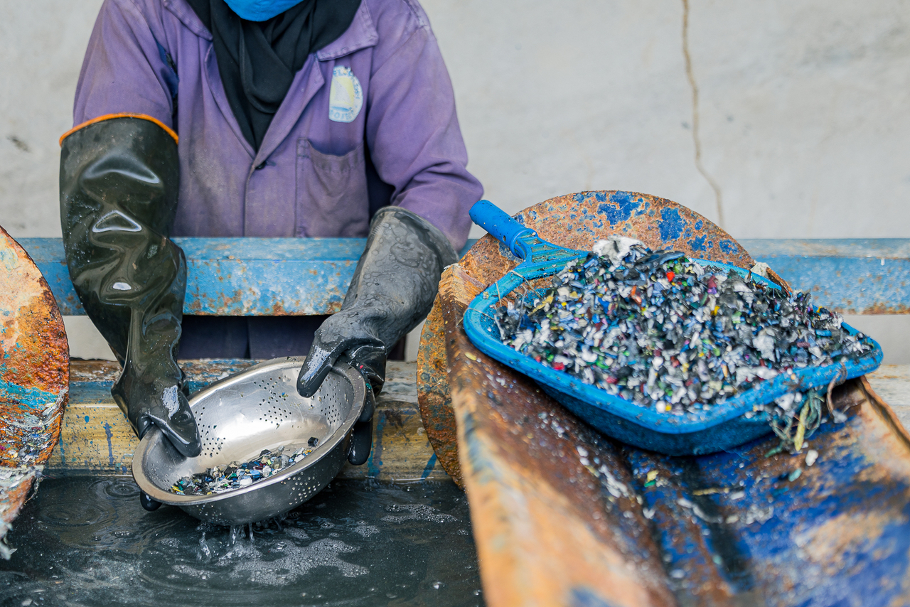 Fatuma Galgalo washes shredded plastic before further processing at Flipflopi's workshop in Lamu, Kenya.